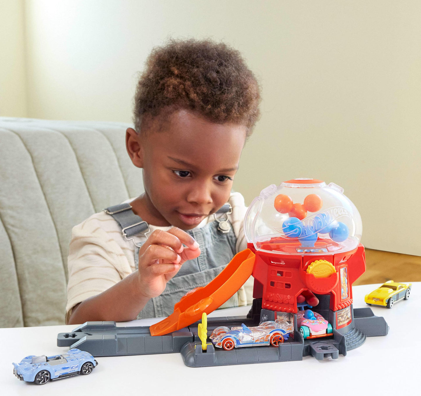 Hot Wheels Toy Car Track Set, Gumball Machine Playset with 1:64 Scale Die-Cast Donut-Shaped Vehicle & Speed Snap Track, Downtown City Candy Shop